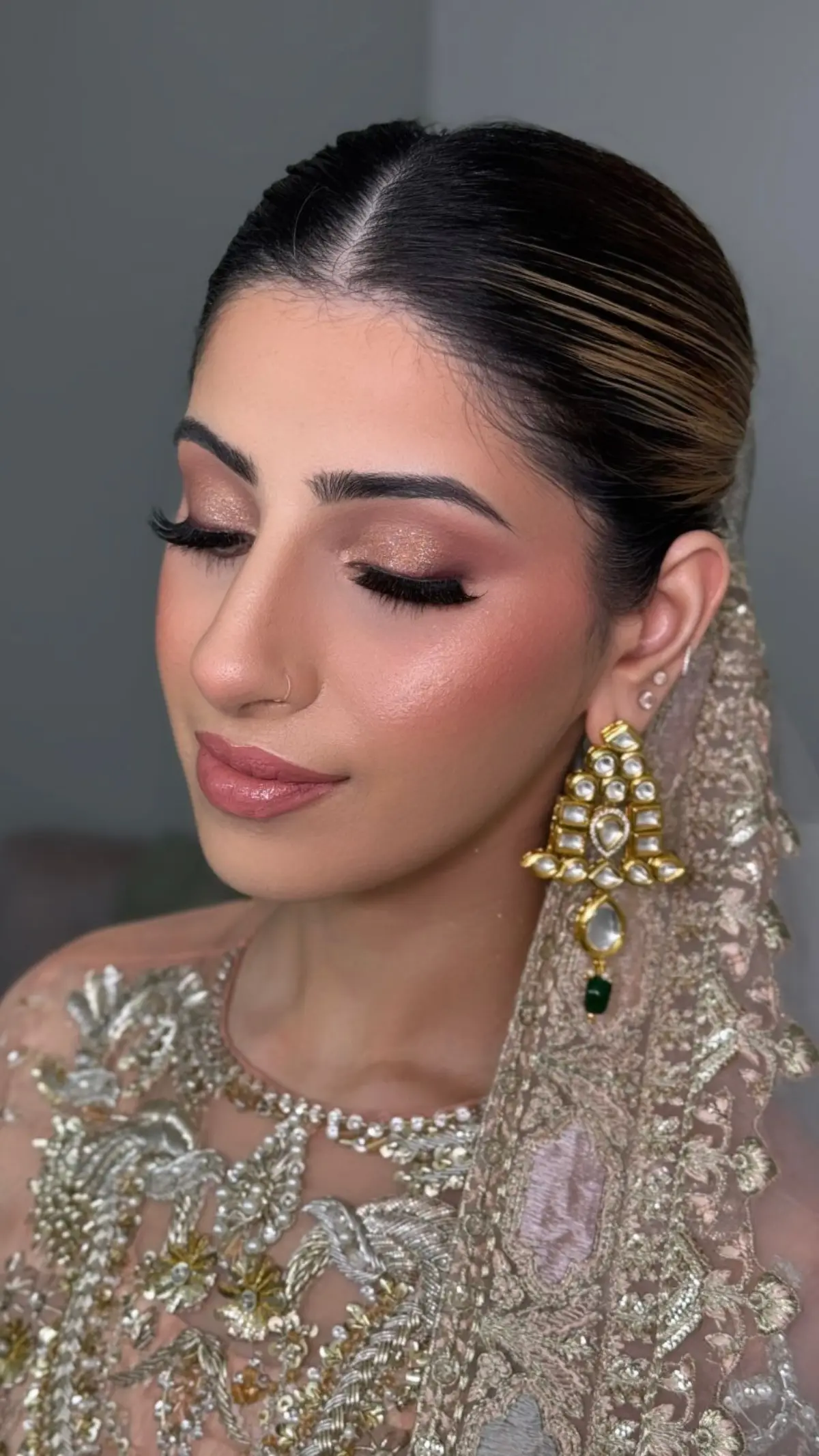 Bride in a richly embroidered gold and red ensemble with layered necklaces.