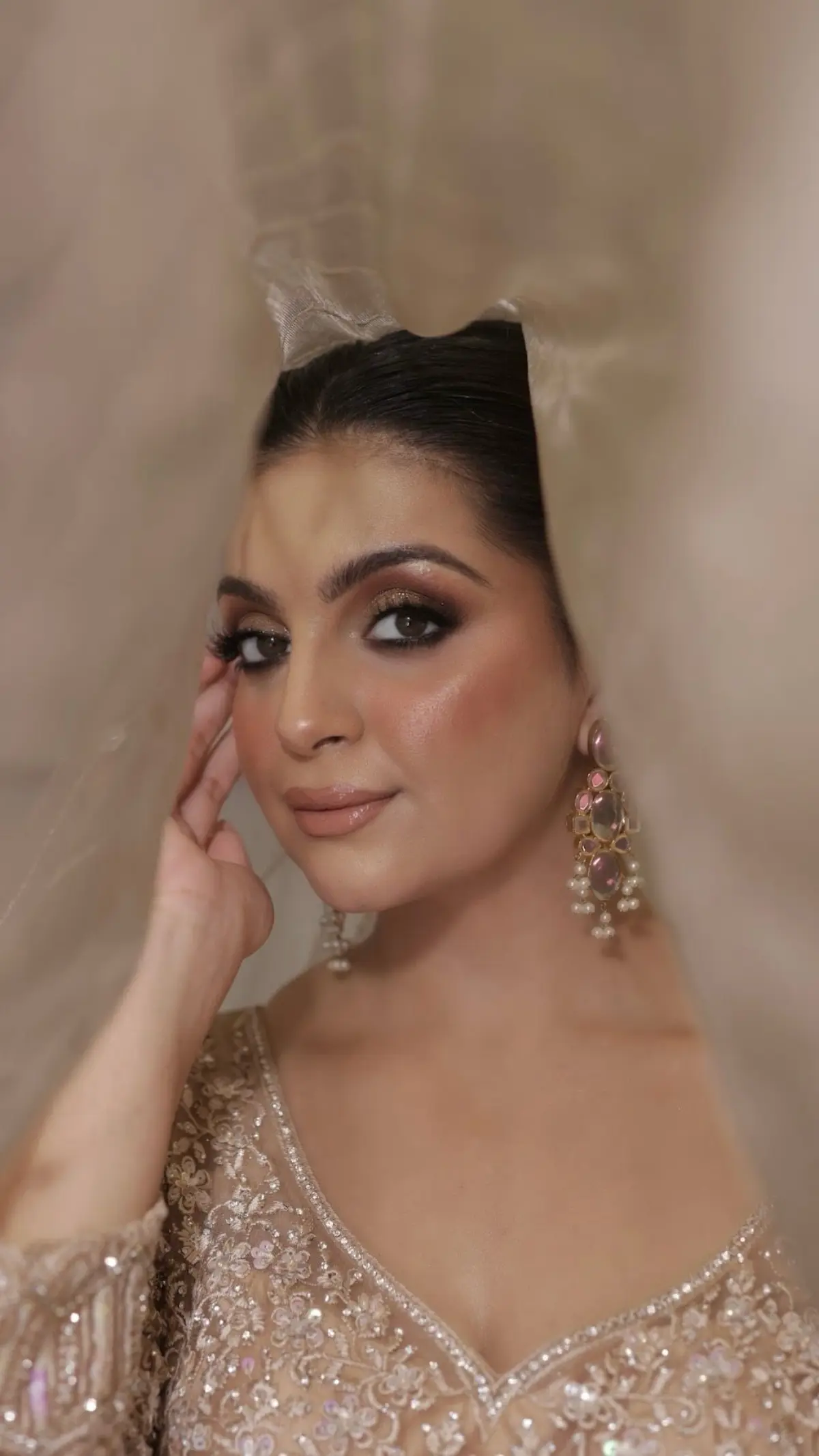 Bride in soft neutrals with a delicate diamond set and a smooth centre-parted style.